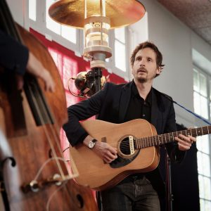 Concert de Bonjour Sourire, un guitariste joue et regarde le contrebassiste